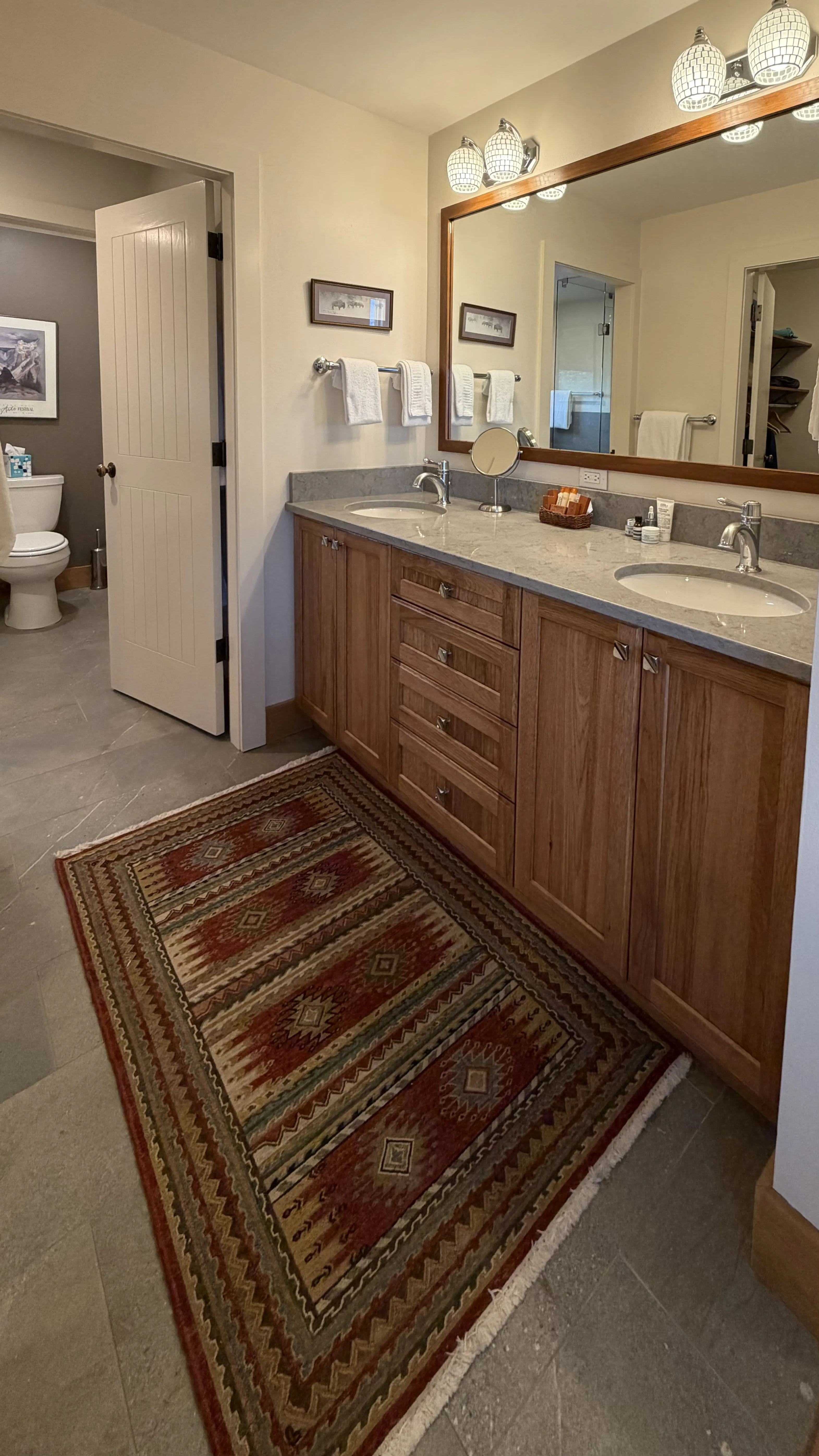 Master bathroom double vanity with marble countertop, oak cabinets and large framed mirror - Spring Creek Ranch Jackson Hole