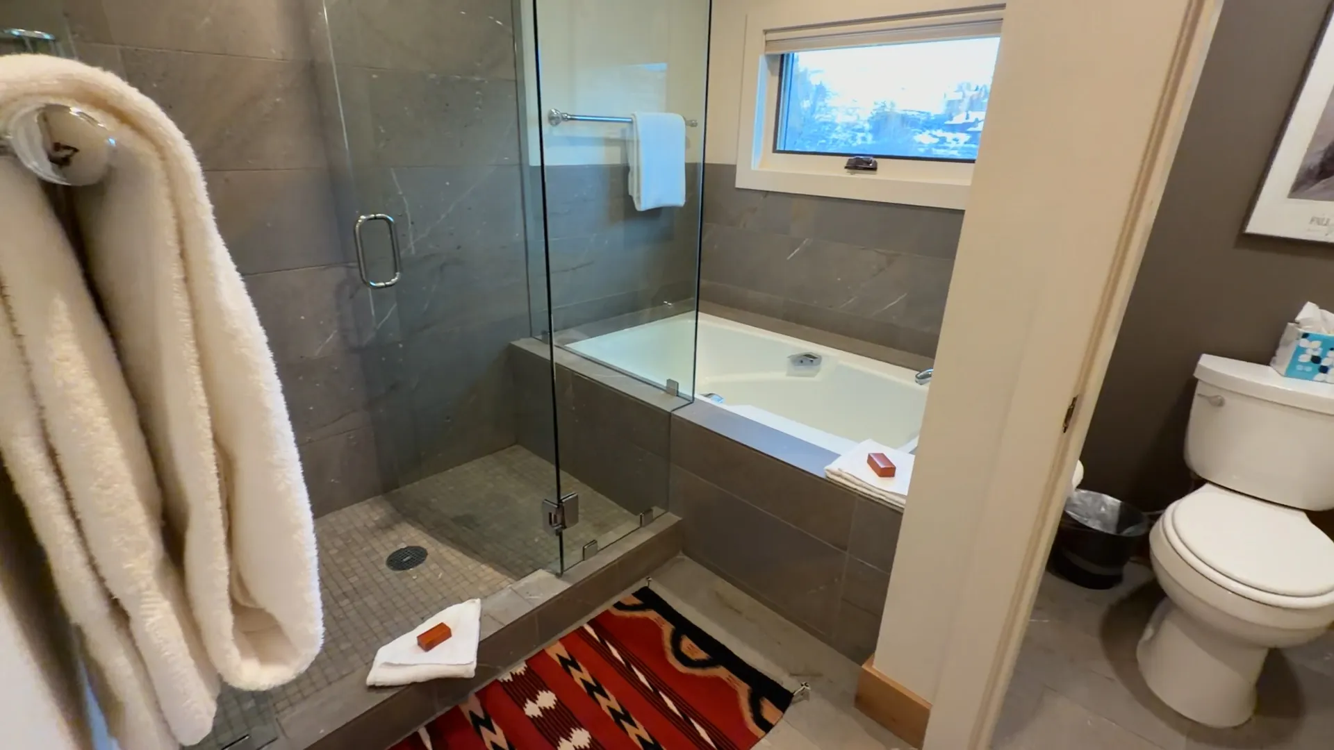 Master bathroom glass walk-in shower and soaking tub with window - Spring Creek Ranch luxury rental